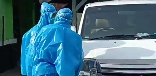Petugas medis menggunakan jas hujan/net