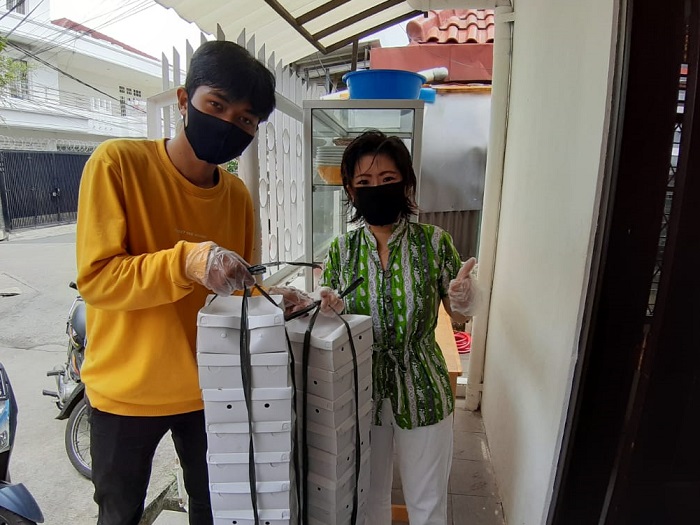 Penyerahan nasi kotak ke koordinator ke relawan RS Covid-19 Wisma Atlet/foto: Istimewa