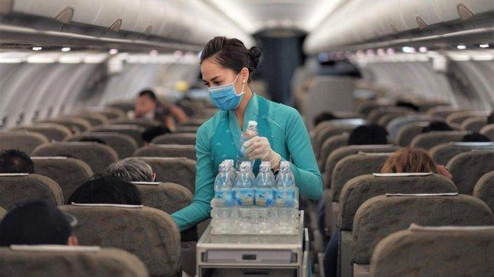 Pramugari Vietnam Airlines mengenakan masker saat melayani penumpang di kabin pesawat/business traveller