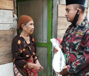 Salah Satu Pengurus Daerah Pemuda Muhammadiyah Kota Gunungsitoli membagikan sembako berupa beras kepada salah seorang warga/Foto:istimewa