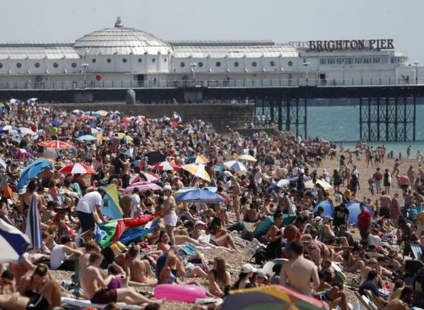 Para pengunjung pantai menikmati sinar matahari dan laut menjadi hari terpanas di Inggris tahun ini, di Brighton, Jumat, 31 Juli 2020 (Foto AP)