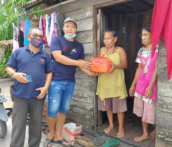 Rudianto (kedua kiri) memberikan langsung paket sembako secara door to door ke rumah warga di Kecamatan Tebas dan sekitarnya, Minggu (15/11/2020)/ist