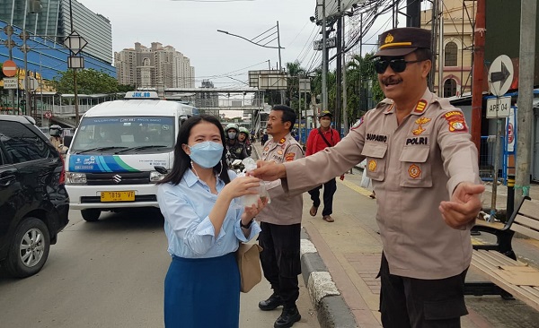 Kanit Binmas Polsek Pademangan AKP Suparno membagikan takjil di Perempatan Lampu Merah Mangga Dua, Jakarta Utara, Selasa (28/3/2023)